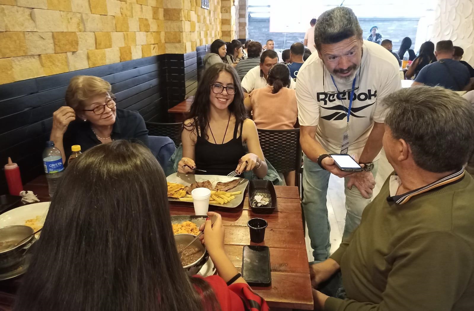 El periodista ciudadano Rafael Cruz entrevista algunos comensales del restaurante ‘Caldo Parao’ para su crónica sobre este icónico restaurante. Foto: Roberto Quiroga B. – noticiasmayores.com